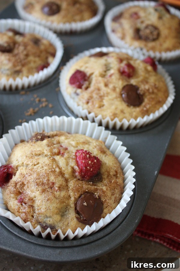 Basket of freshly baked Dark Chocolate Chip Raspberry Banana Jumbo Muffins, some with a visible sugar-cinnamon topping.