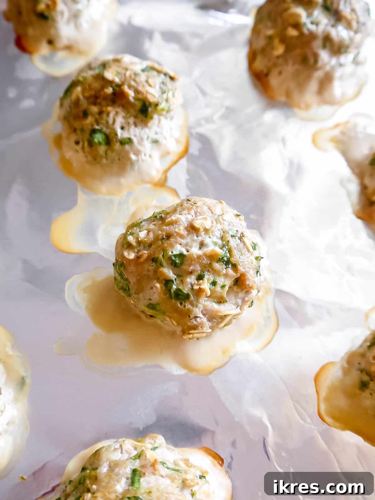 Lean & Green Baked Turkey Spinach Meatballs (Gluten-Free) 6 Golden brown baked turkey spinach meatballs on a baking sheet after cooking.