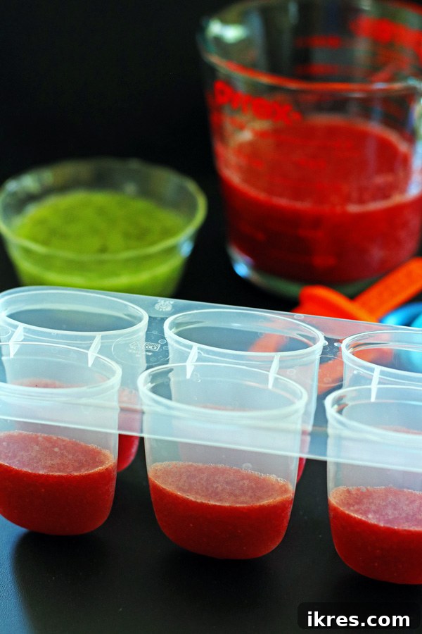 Refreshing Fruit Freezes 6 Strawberry and Kiwi puree in pyrex containers with popsicle molds partly filled up