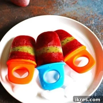Refreshing Fruit Freezes 9 Strawberry Kiwi Popsicles on a white plate sitting on a multi-colored counter