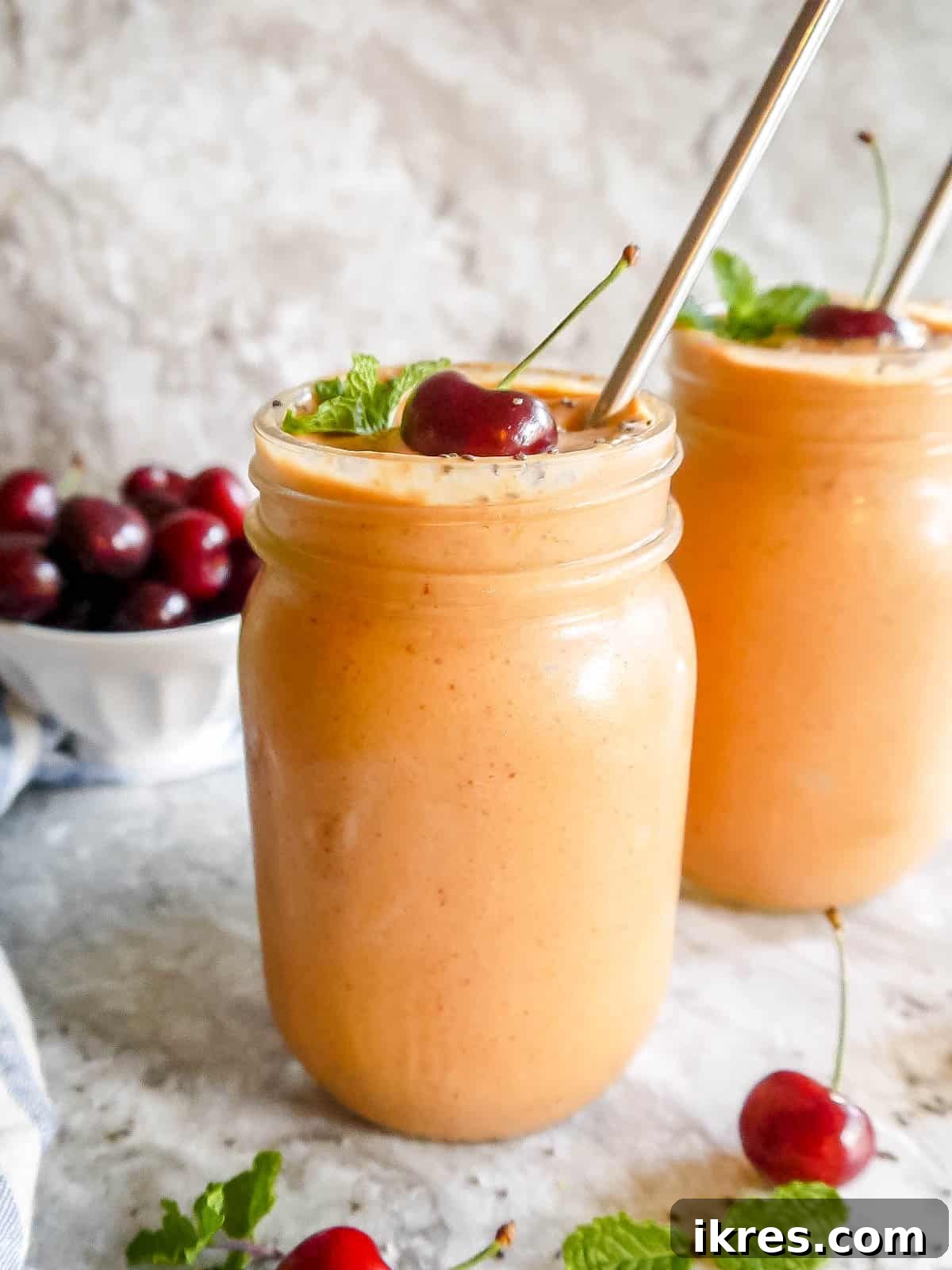 Creamy Cherry Mango Carrot Greek Yogurt Smoothie 2 Vibrant Cherry Mango Carrot Smoothie in a glass, garnished with fresh fruit, showcasing its delicious appeal.