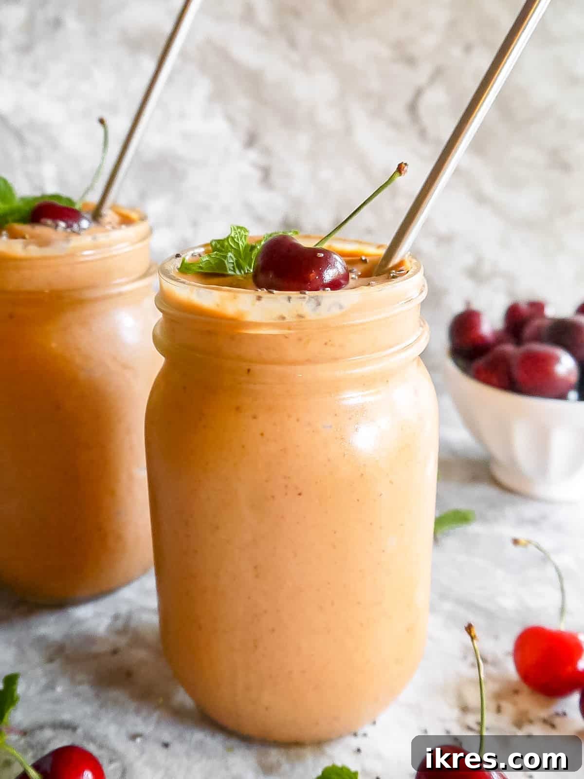 Creamy Cherry Mango Carrot Greek Yogurt Smoothie 5 Two mason jars filled with creamy mango carrot yogurt smoothie, ready to be enjoyed.