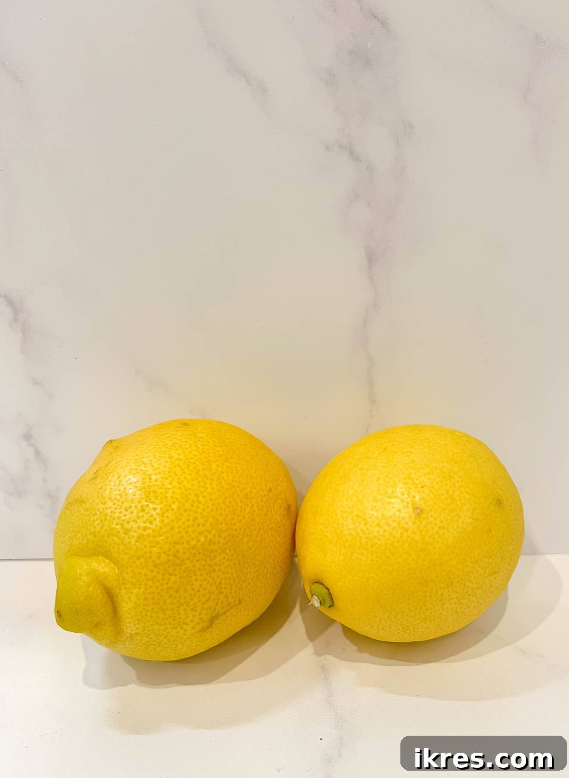 Vibrant fresh lemons, ready to be zested and juiced, highlighting the key flavor of the cookies.