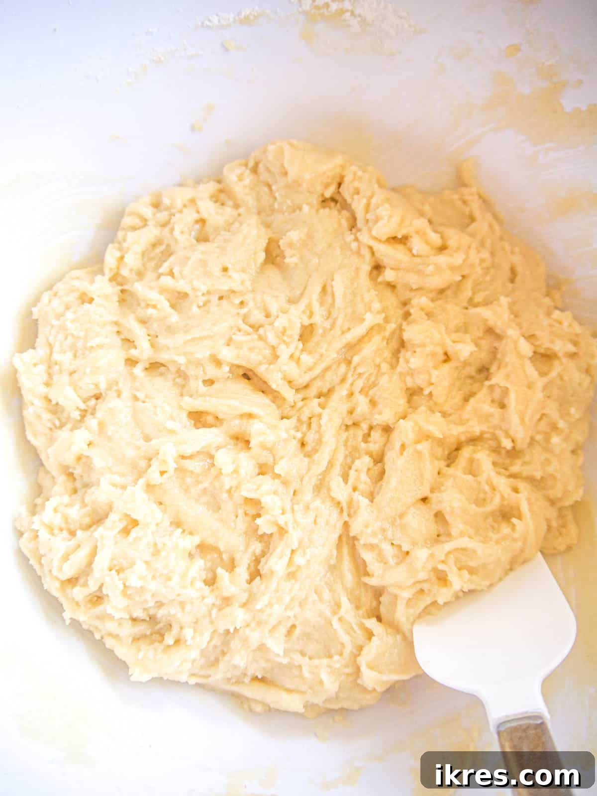 Lemon sugar cookie dough showing the wet ingredients mixed together with a hand mixer.