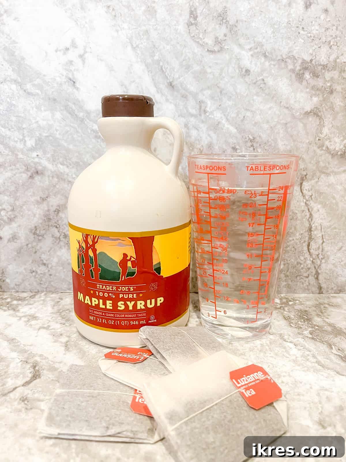 Ingredients laid out for making Maple Iced Tea, including black tea bags, water, and pure maple syrup.