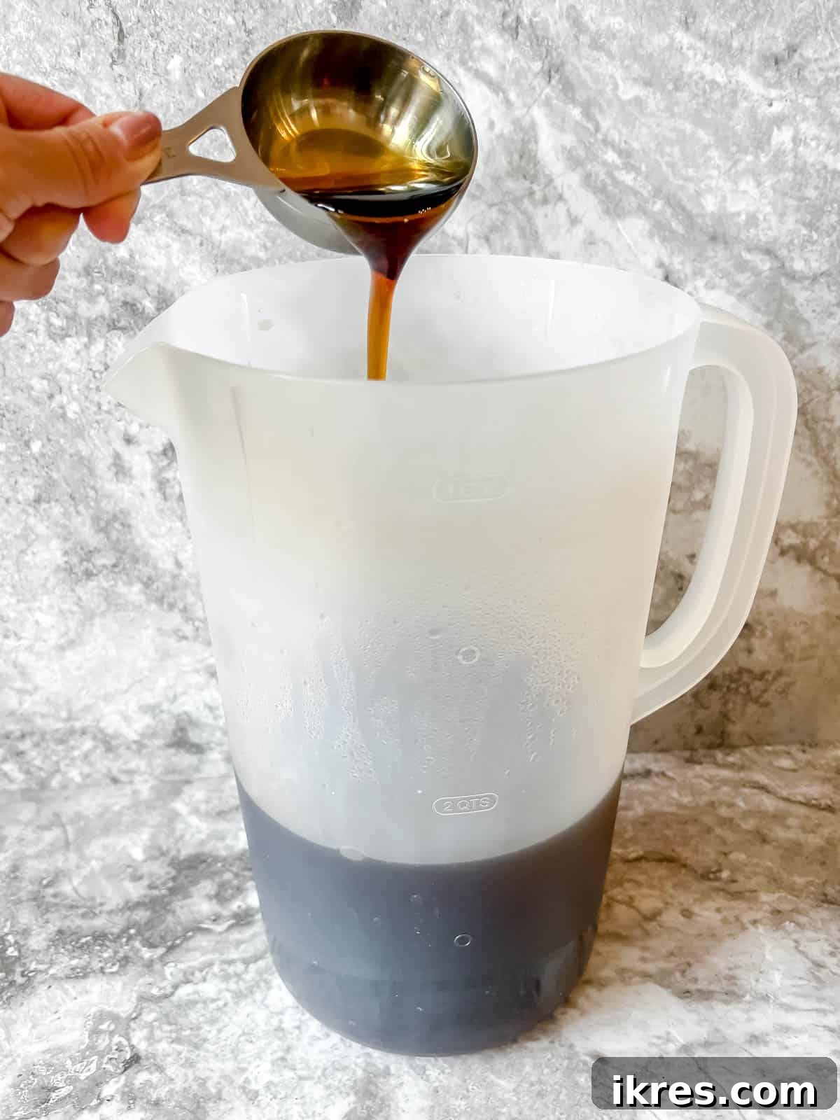 Pure maple syrup being stirred into the freshly brewed black tea.
