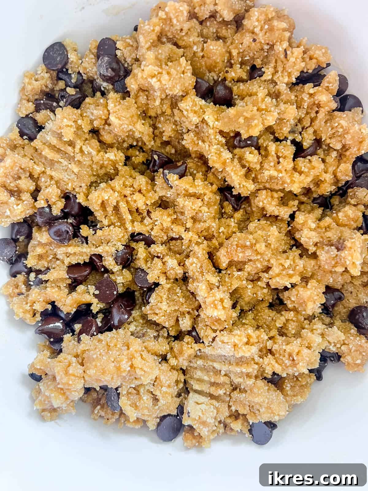 Golden Yolk Almond Chocolate Bars 6 Almond flour cookie bar dough in a bowl, with chocolate chips folded in.