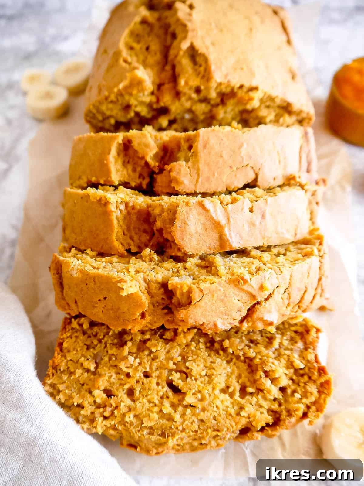 Sliced Healthy Pumpkin Banana Bread ready to be enjoyed on a rustic wooden table.