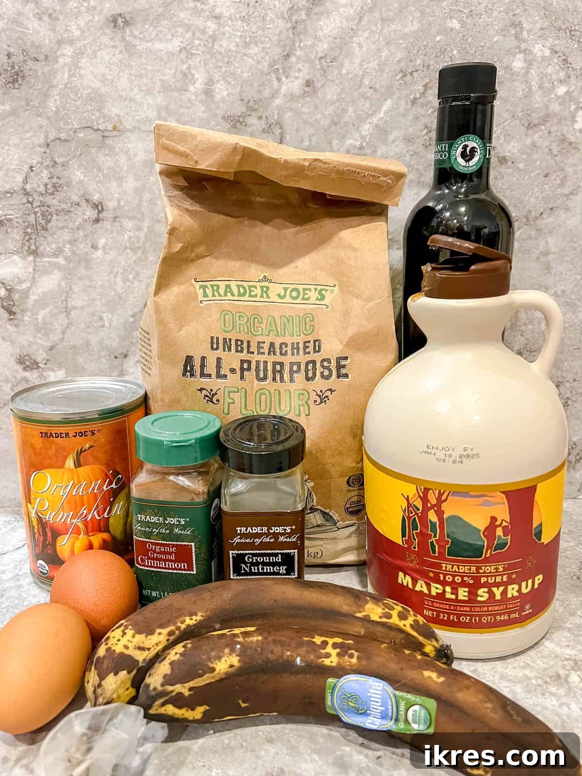 A flat lay photograph showcasing all the fresh ingredients needed to bake healthy pumpkin banana bread.