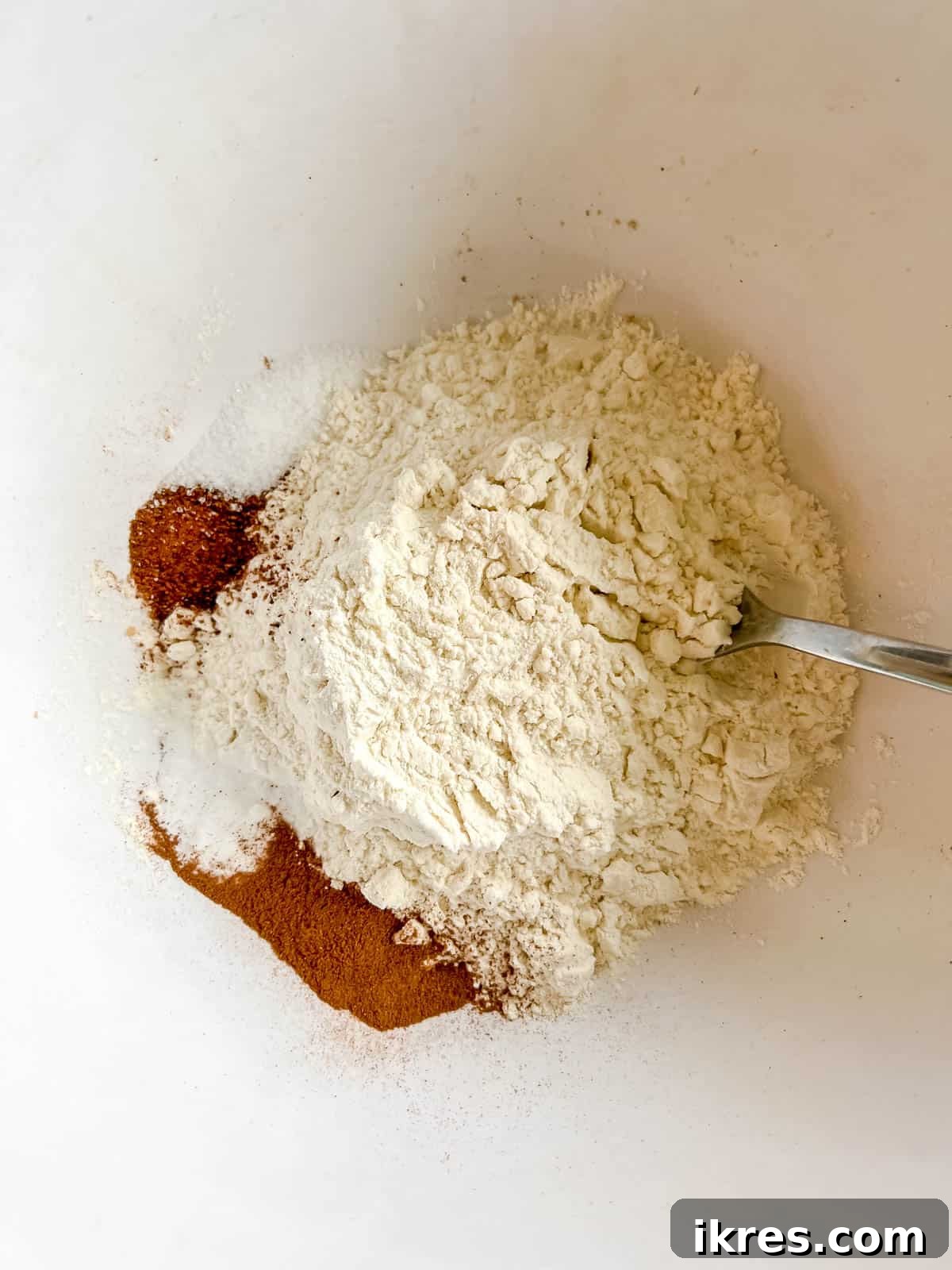 Dry ingredients for pumpkin banana bread mixed in a large mixing bowl.