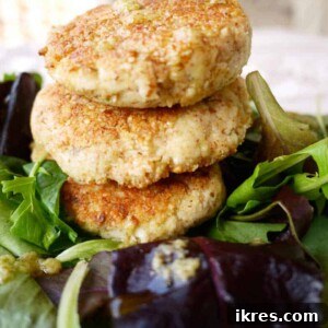 Paleo Crispy Lemon-Thyme Fish Cakes (GF) - A close-up shot of a perfectly pan-fried fish cake, golden and crispy.