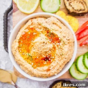 Cauliflower hummus in a bowl with roasted eggplant and peppers inside, ready to be served.