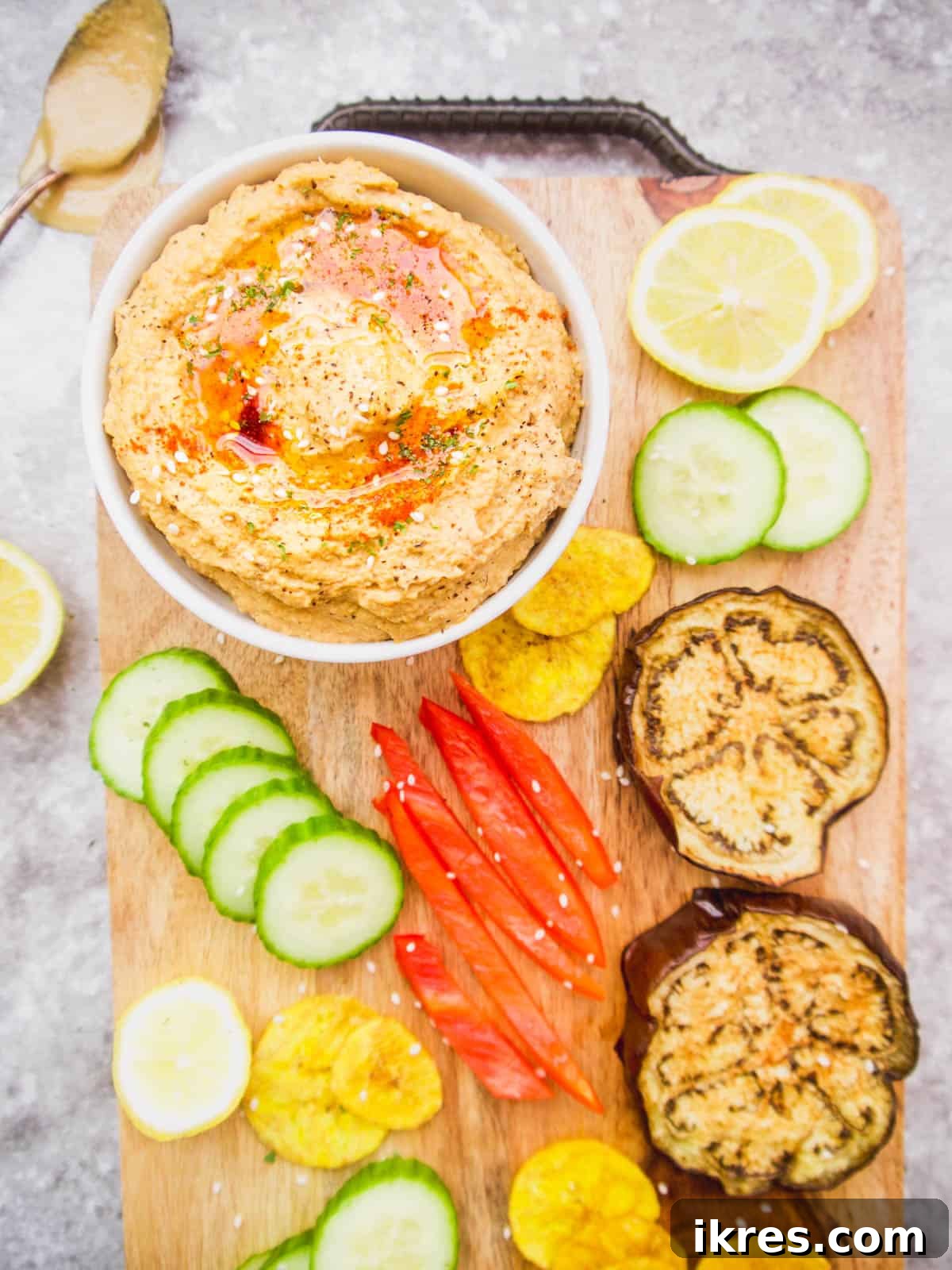 Delicious Paleo hummus artfully arranged on a serving tray, surrounded by a variety of crisp vegetables and crunchy chips, ready for dipping.