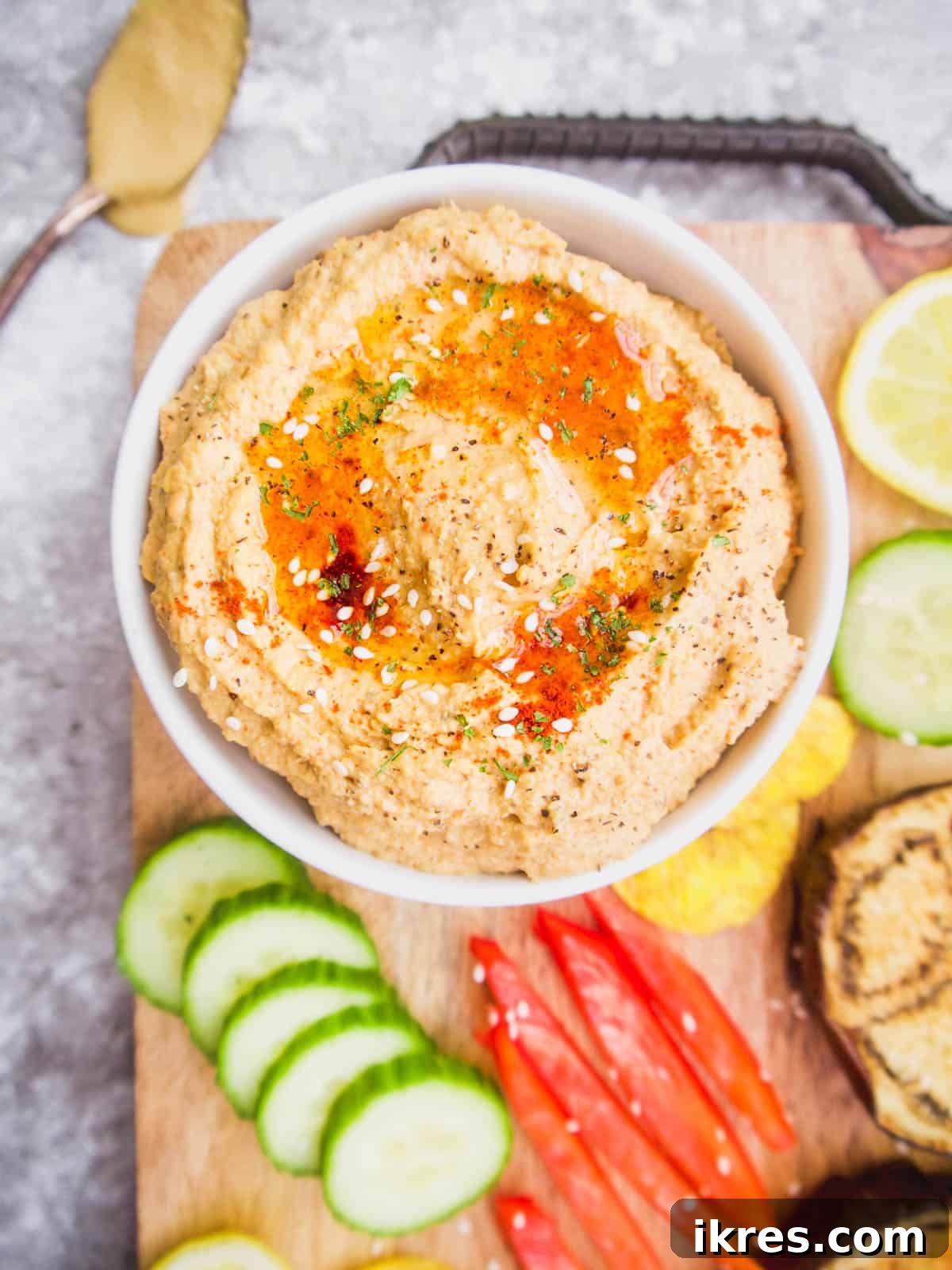A wide shot of a serving tray filled with vibrant Mediterranean Hummus, fresh vegetables, and various dipping options, perfect for entertaining.