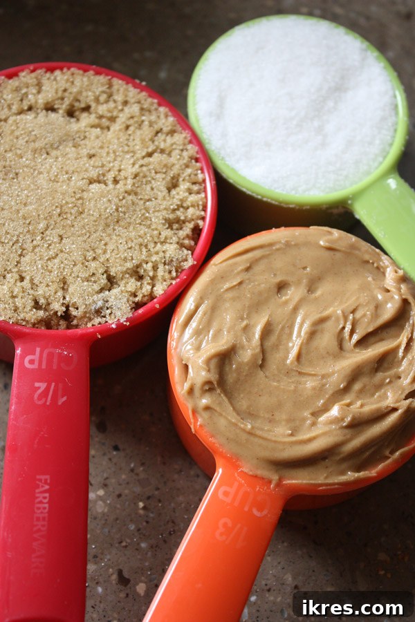 Decadent Peanut Butter Chocolate Chip Cookies 3 Close-up of butter, brown sugar, granulated sugar, and creamy peanut butter in a mixing bowl for jumbo cookies.