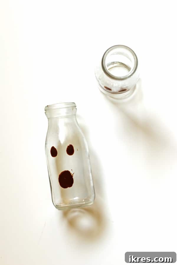 Monster Milkshake Creations 3 Close-up of clear glasses with melting chocolate chip faces already drawn on the interior, ready to be chilled and filled for Halloween Ghost Milkshakes.