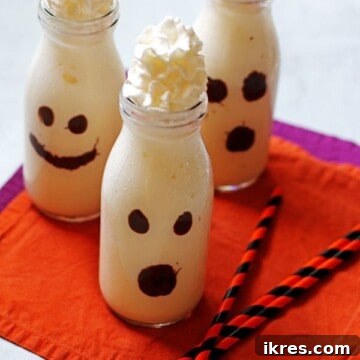 Vanilla milkshakes that are in a clear glass and decorated as ghosts