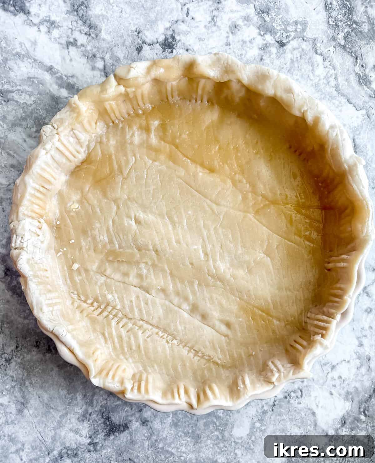 No-Fuss Apricot Tart with Premade Pastry 5 A store-bought pie crust carefully placed into a tart pan, with edges pressed down.