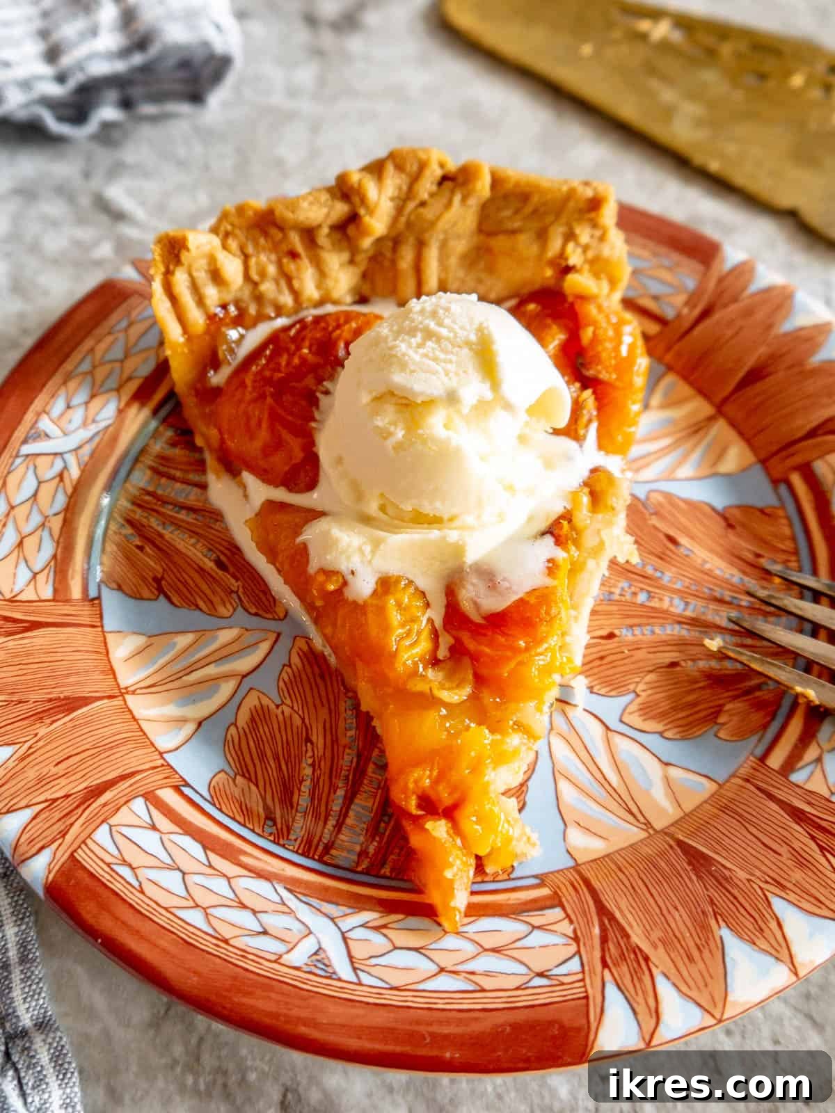 No-Fuss Apricot Tart with Premade Pastry 9 A perfectly sliced apricot tart served with a scoop of vanilla ice cream.