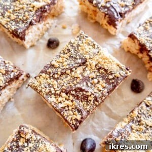S'mores rice krispie treats cut into squares on parchment paper, ready to be enjoyed.