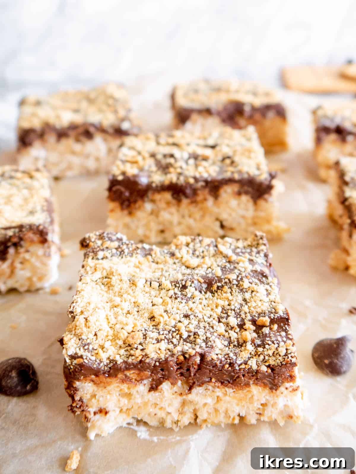 A close-up view of a single S'mores Rice Krispie Treat square, showing the crispy cereal base, the generous chocolate layer, and the sprinkled graham cracker crumbs.