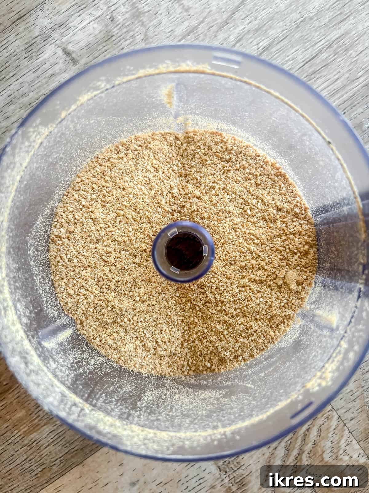 Graham crackers being crushed into fine crumbs in a food processor, ready for the S'mores Rice Krispie Treats recipe.