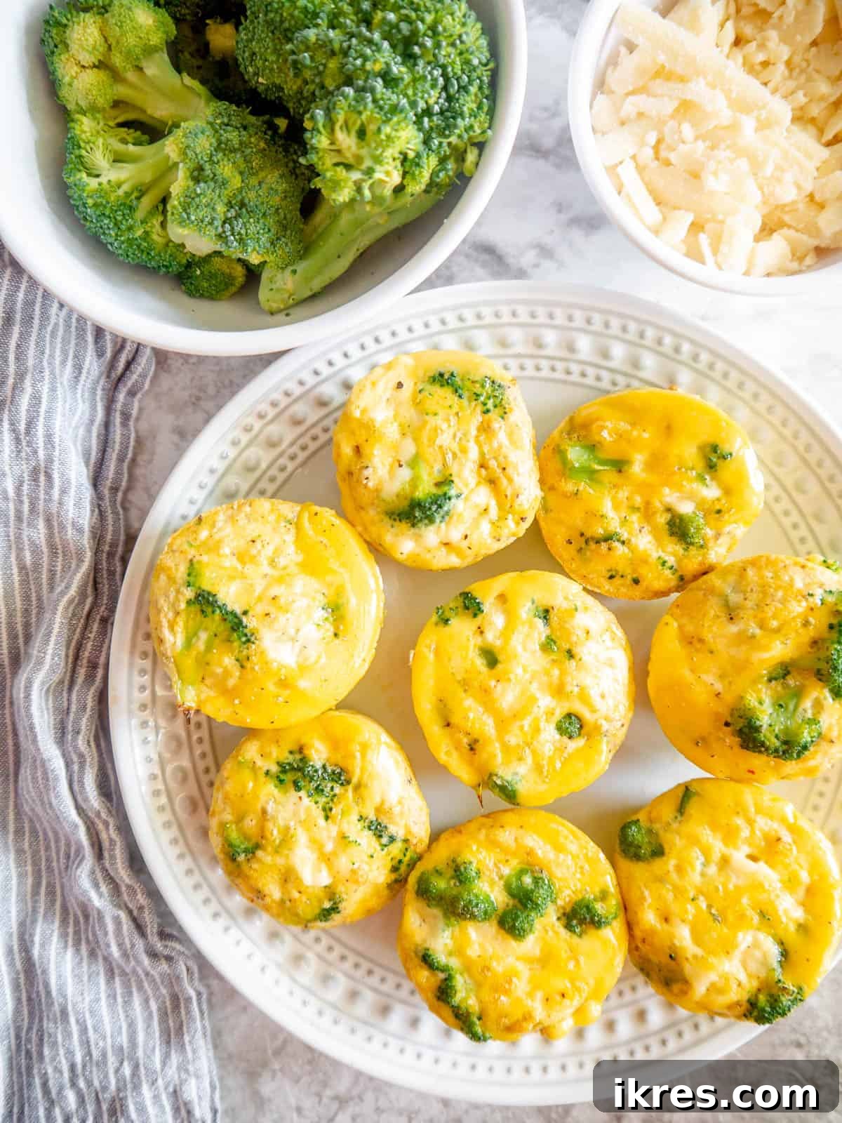 A close-up of several fluffy broccoli cheddar egg bites arranged attractively on a plate, ready to be served.