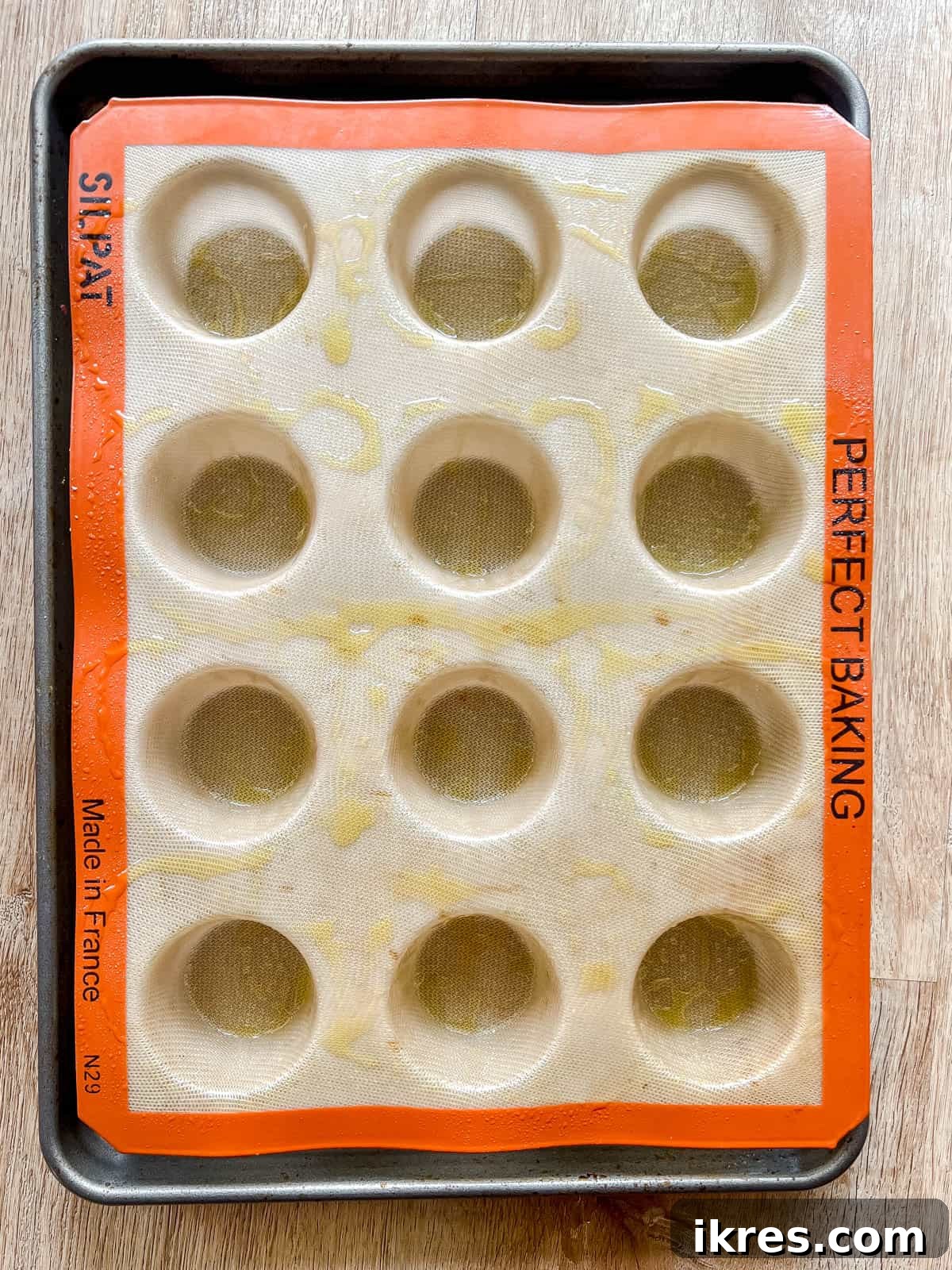 A silicone muffin mold freshly greased and ready for the egg mixture.