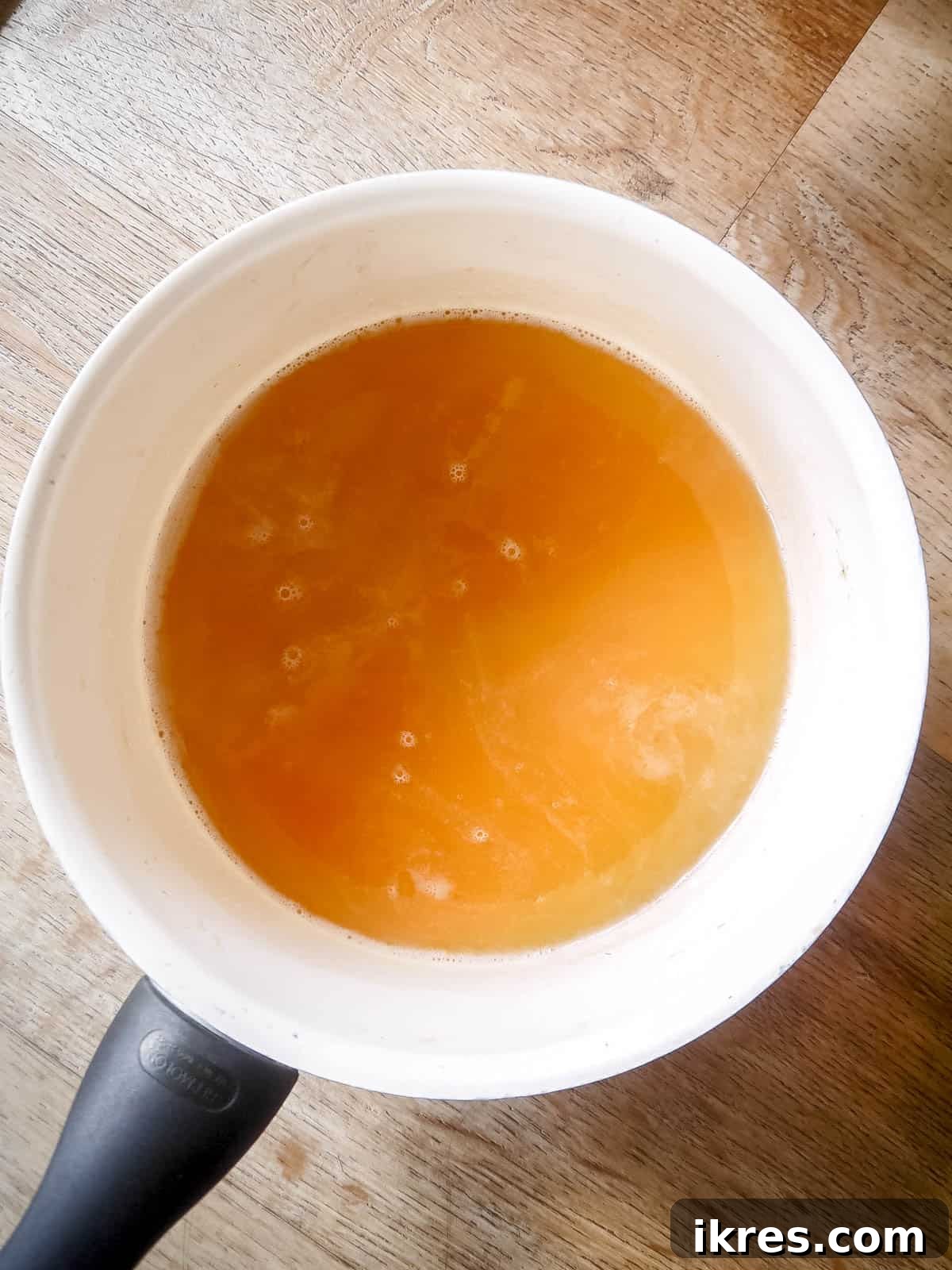 DIY Apple Gummy Delights 6 Bloomed gelatin being stirred into the hot apple juice mixture.