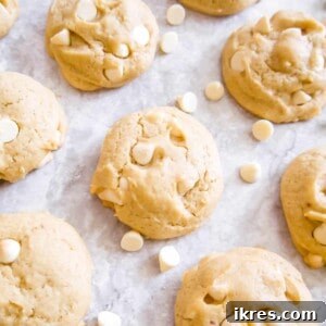 Mouthwatering white chocolate chip cookies, showcasing their perfect golden-brown exterior and abundant white chocolate chips, making for an irresistible treat.
