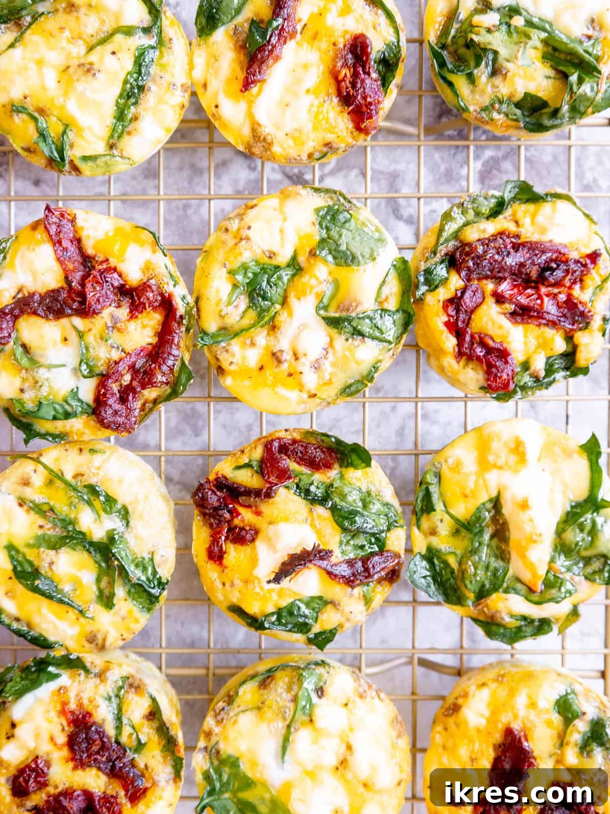 Mediterranean Spinach Feta Egg Muffins 3 Two spinach feta egg cups served on a white plate, ready to eat.