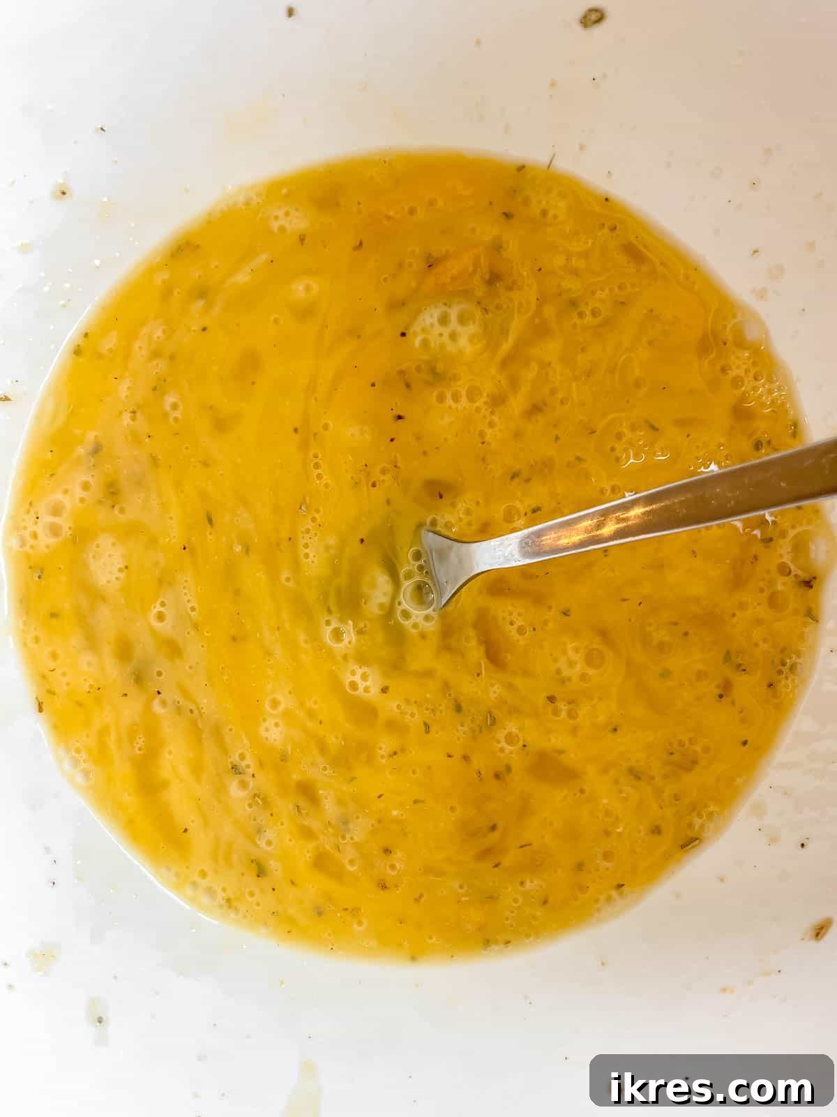 Mediterranean Spinach Feta Egg Muffins 5 Eggs mixed together in a large mixing bowl, showing a smooth, consistent yellow color.