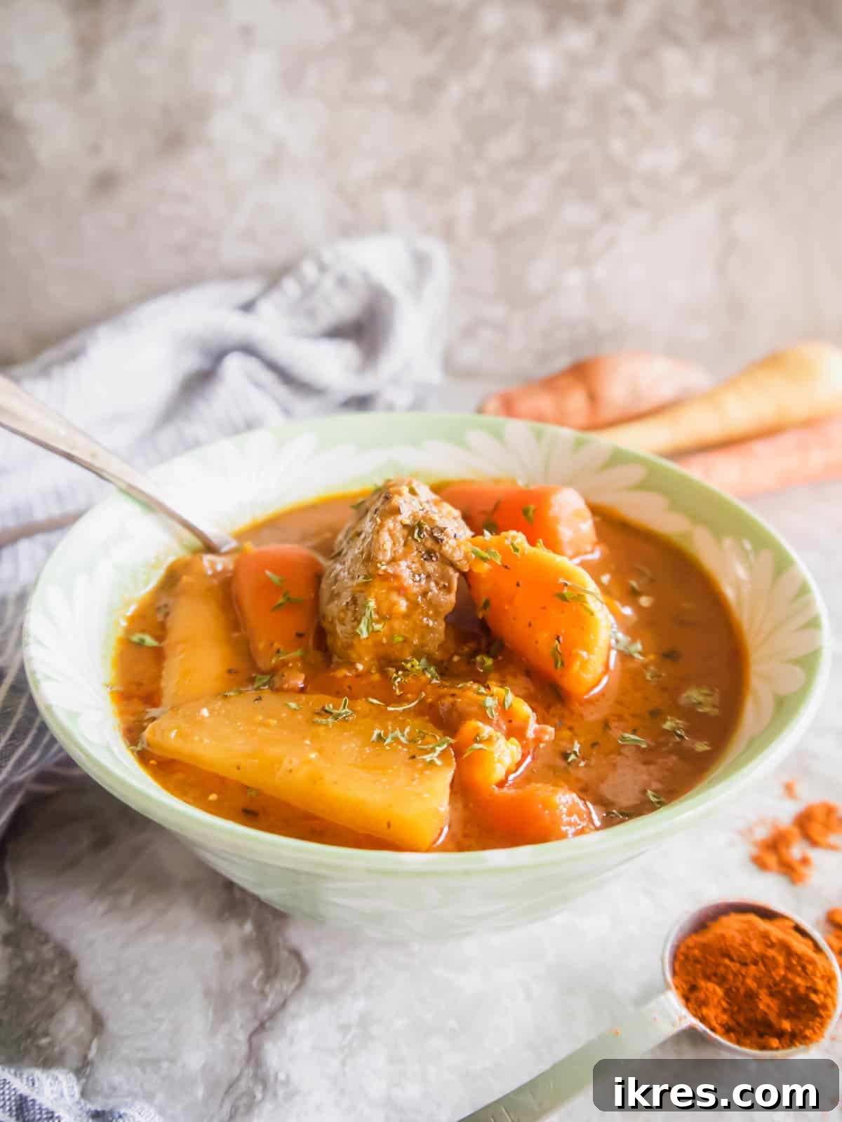A steaming bowl of Slow Cooker Hungarian Goulash, garnished with fresh herbs, ready to be served.