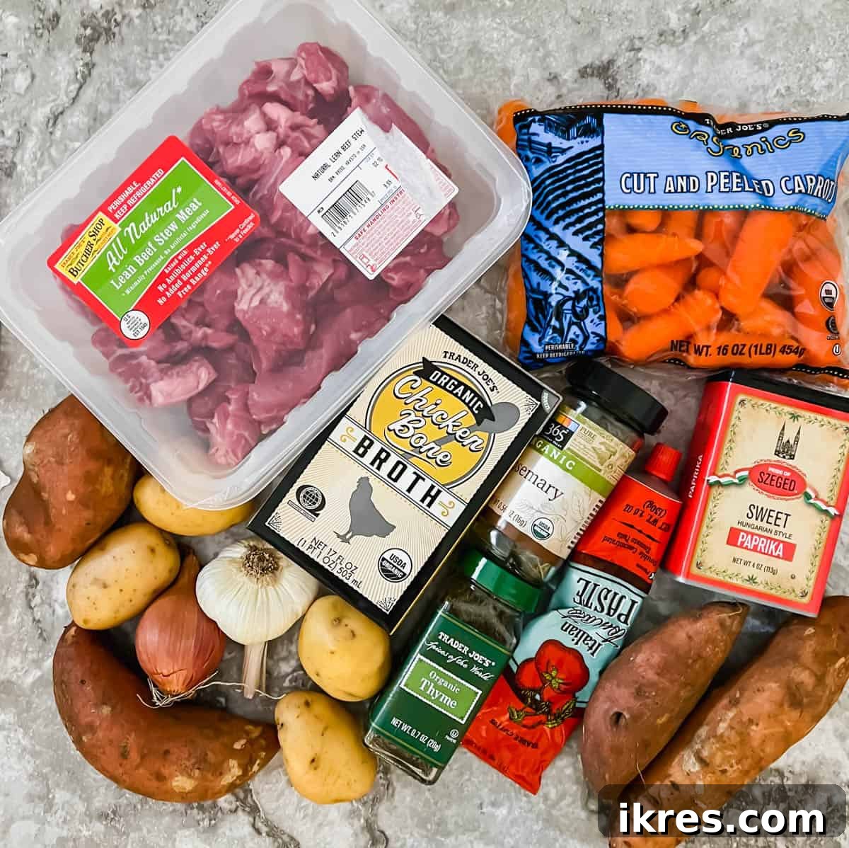 Arrangement of fresh ingredients, including beef cubes, vegetables, and spices, for Healthy Slow Cooker Hungarian Goulash Beef Stew.