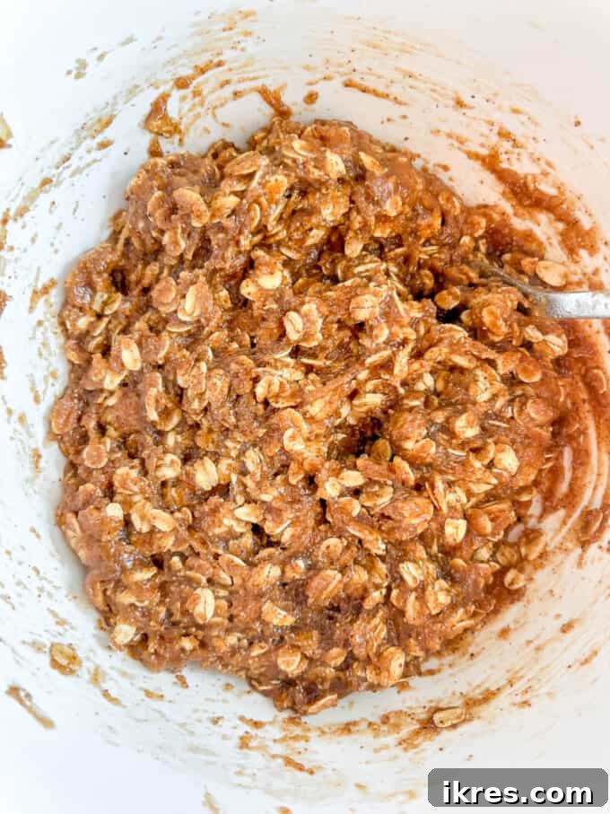 Gluten-free monster cookie batter forming a thick, uniform consistency after combining wet and dry ingredients.