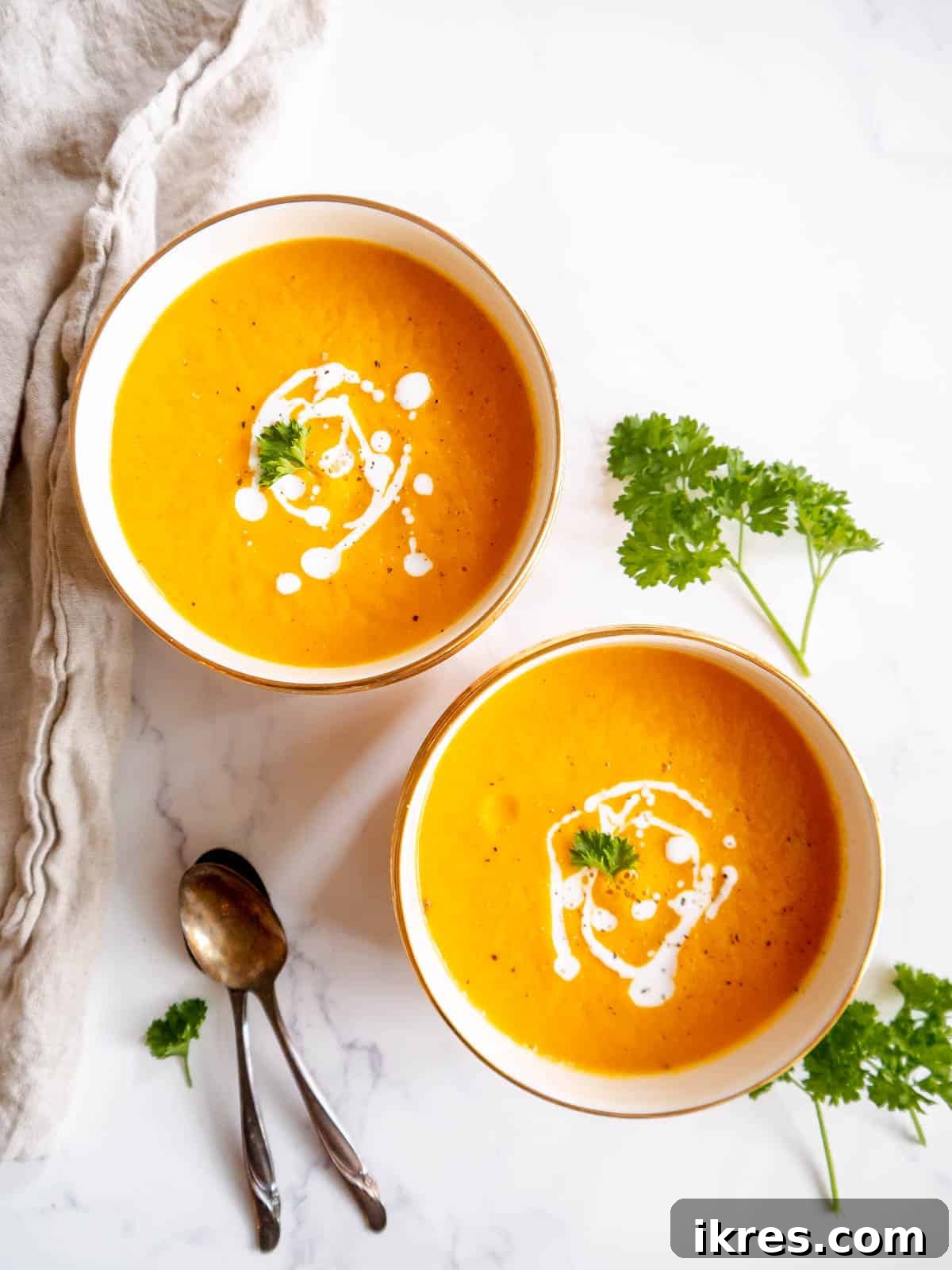 Velvety Butternut Squash and Carrot Soup 11 Two bowls of roasted butternut squash and carrot soup, garnished and ready to eat.