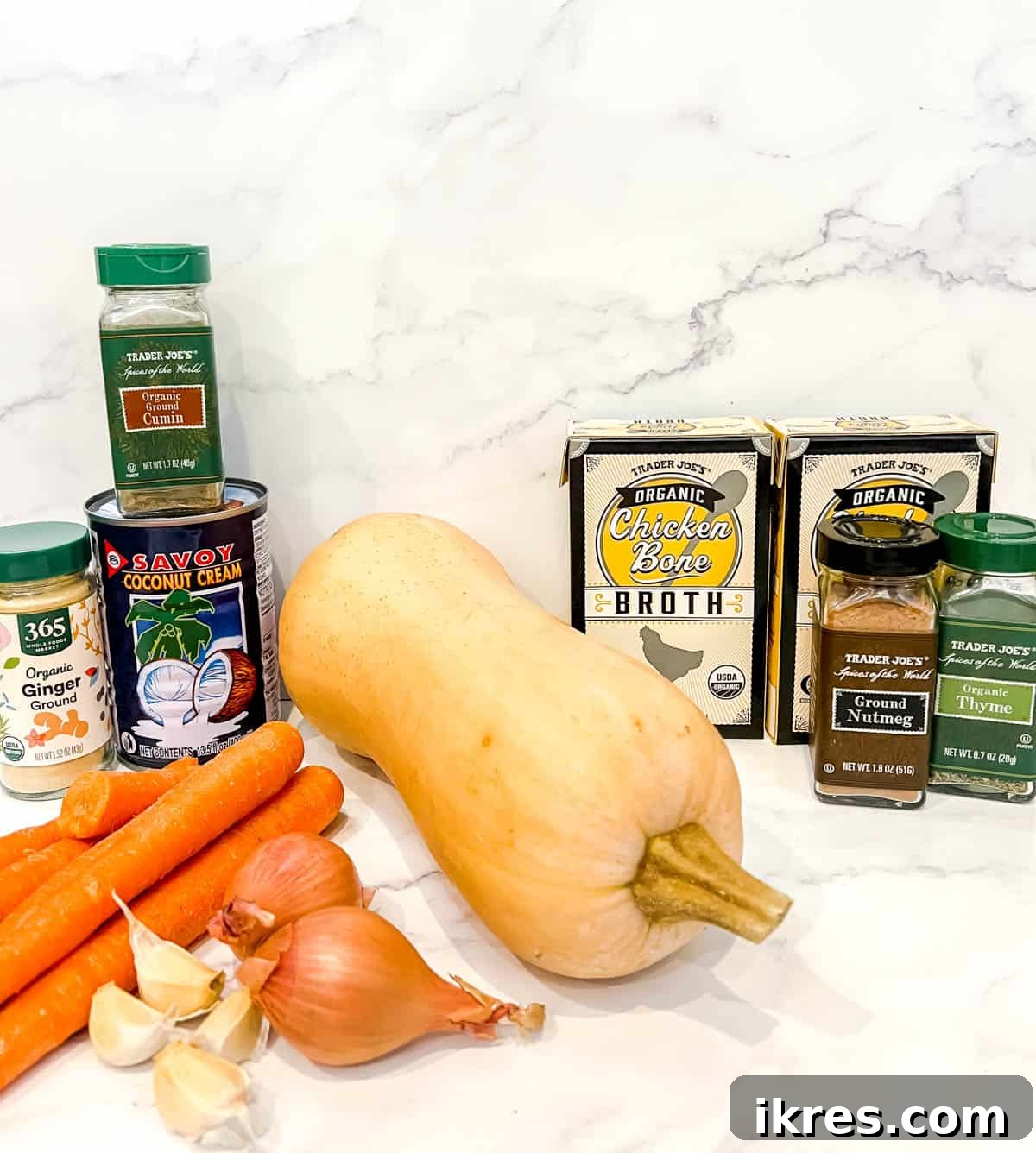 Velvety Butternut Squash and Carrot Soup 3 Ingredients needed to make carrot butternut squash soup laid out on a table.