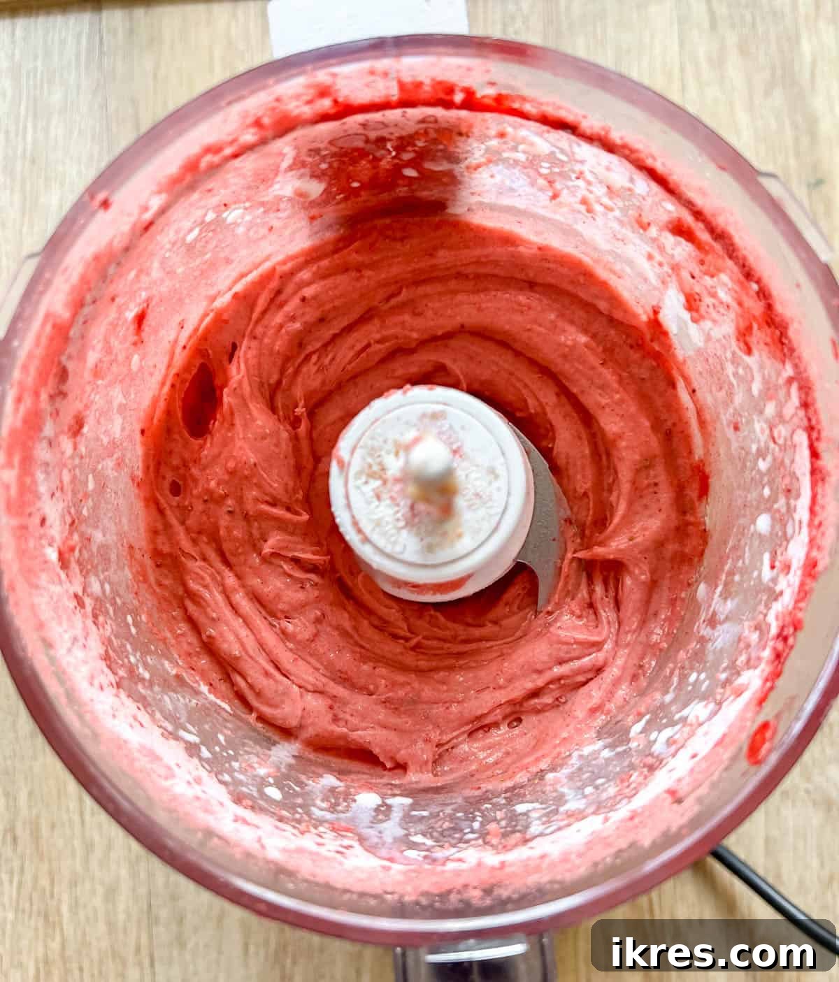 Homemade Small Batch Strawberry Cupcakes 12 Smooth and creamy strawberry frosting being blended in a food processor.