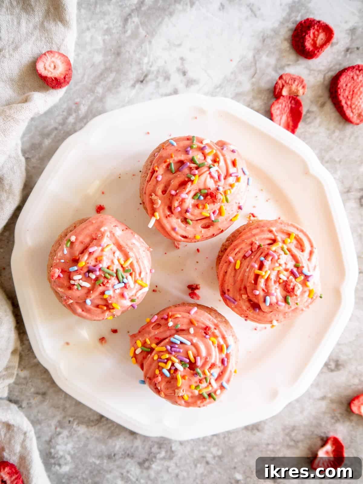 Homemade Small Batch Strawberry Cupcakes 13 Decorated strawberry cupcakes on a plate, ready to be served.