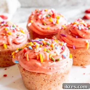 Small Batch Strawberry Cupcakes on a plate with frosting and sprinkles on top.