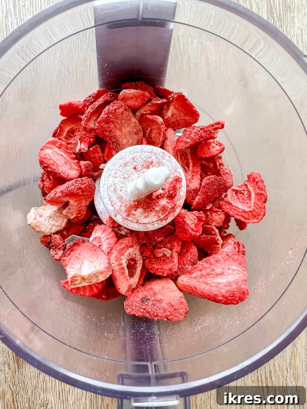 Homemade Small Batch Strawberry Cupcakes 5 Freeze dried strawberries being added to a food processor.