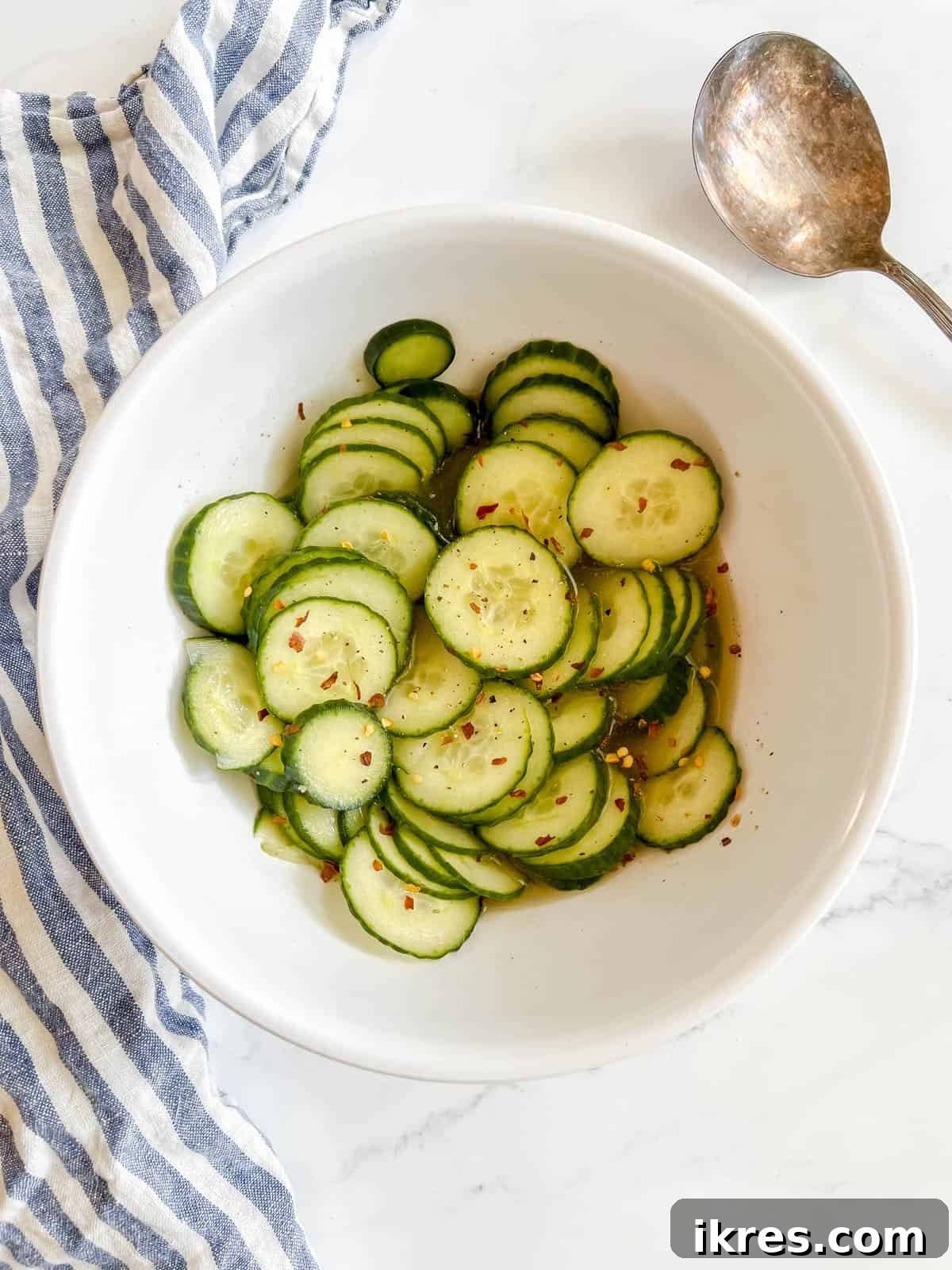 Crisp Asian Quick Pickles 7 A vibrant bowl of quick Asian pickled cucumbers, generously topped with crushed red pepper flakes, showcasing their enticing appeal.