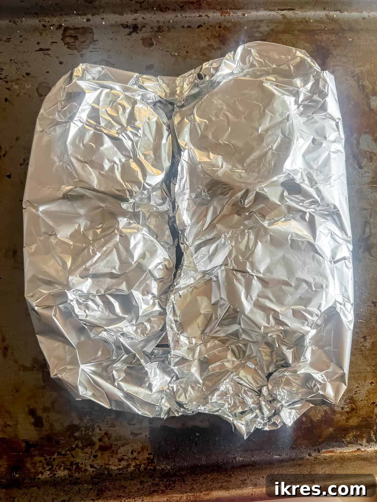 Foil-wrapped salmon baking in the oven, after cooking it to a perfect flaky texture.