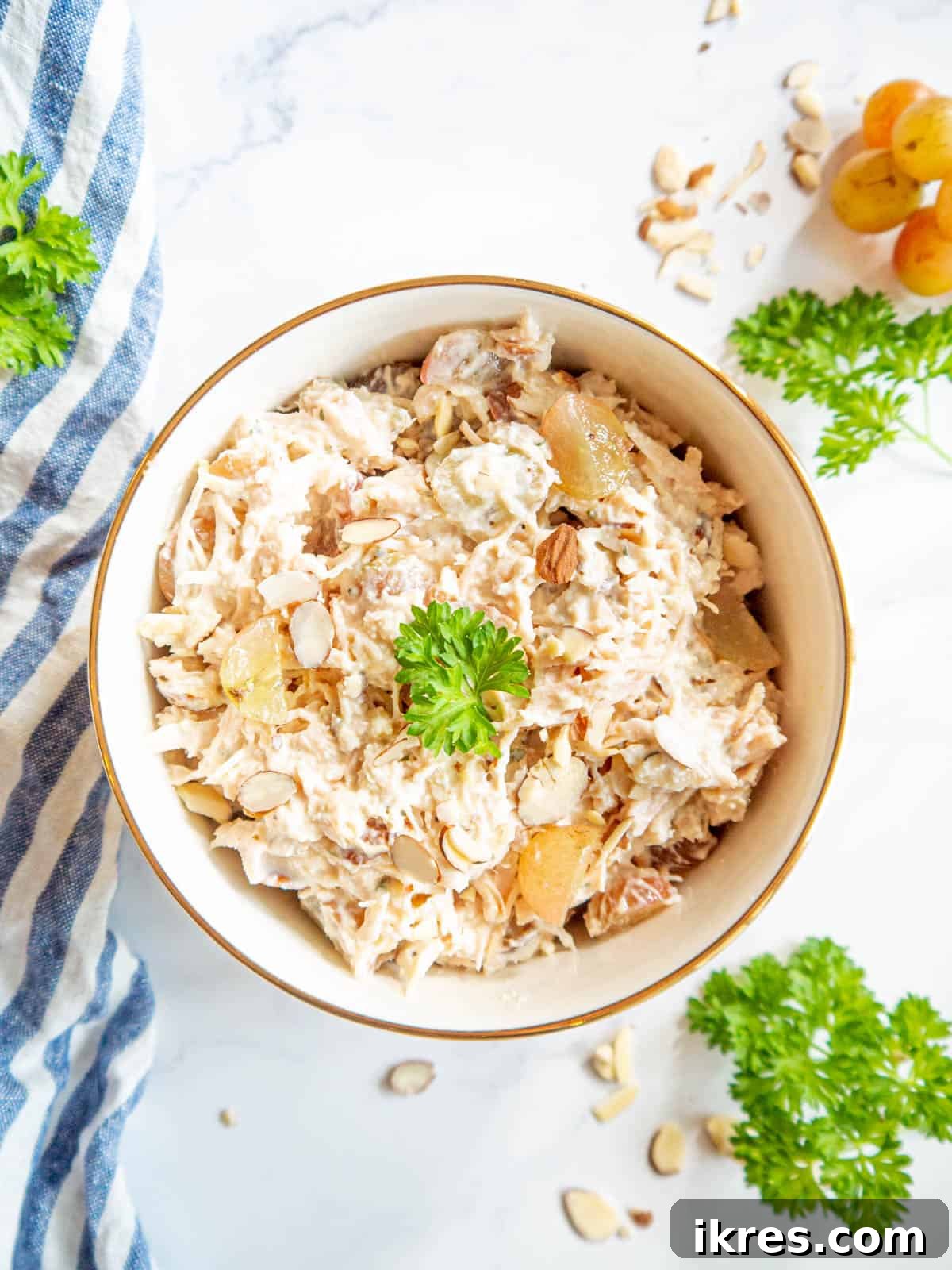 Chicken salad using canned chicken mixed with grapes and almonds in a bowl.