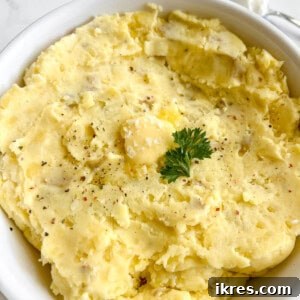 Greek yogurt mashed potatoes in a large bowl with butter melting on top.