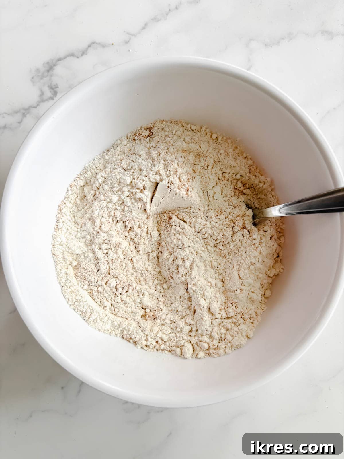 Golden Olive Oil Banana Bread 5 Bowl containing dry ingredients for olive oil banana bread recipe: flour, salt, and baking powder.
