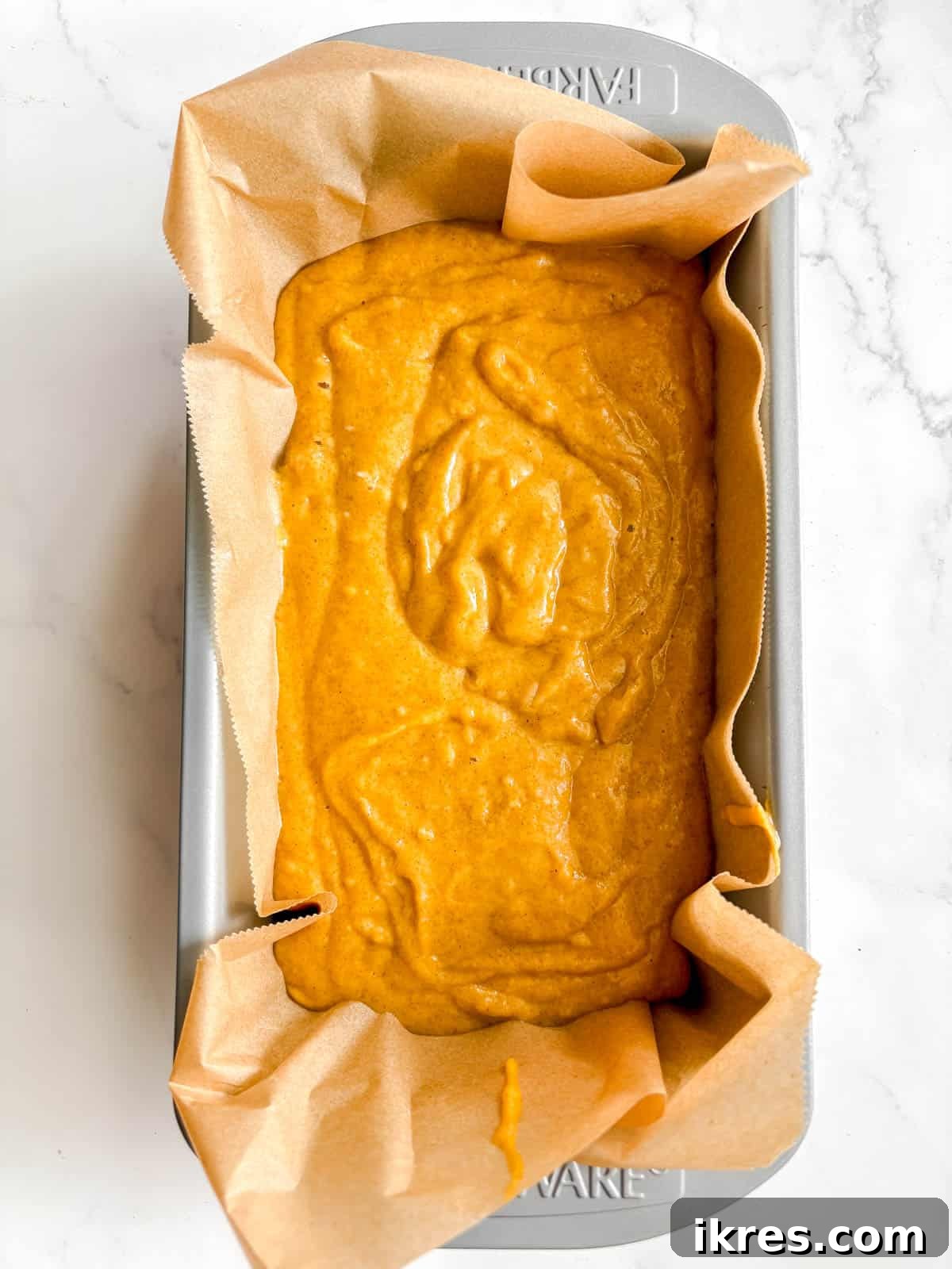Autumn Spiced Dairy-Free Pumpkin Bread 8 The dairy-free pumpkin bread batter poured into a parchment-lined loaf tin, ready for baking.