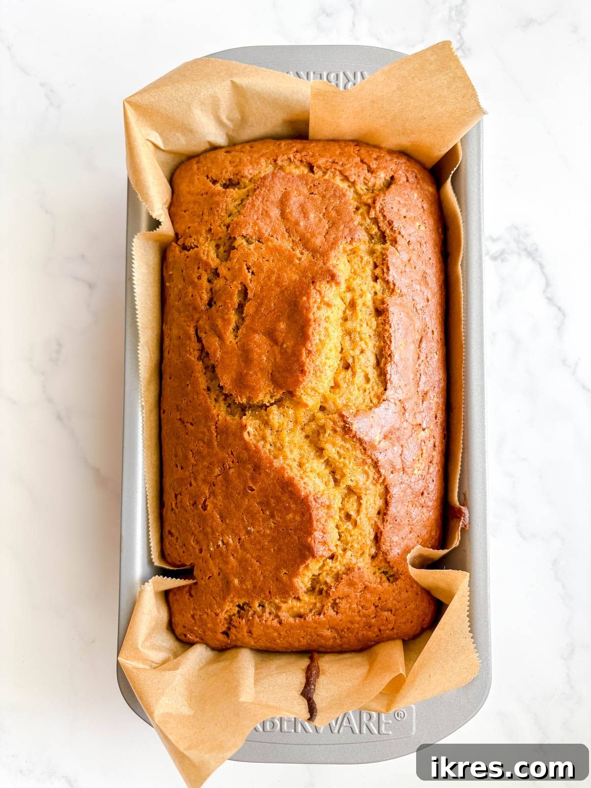 Autumn Spiced Dairy-Free Pumpkin Bread 9 A golden-brown dairy-free pumpkin bread, freshly baked and removed from the oven, indicating it's done.