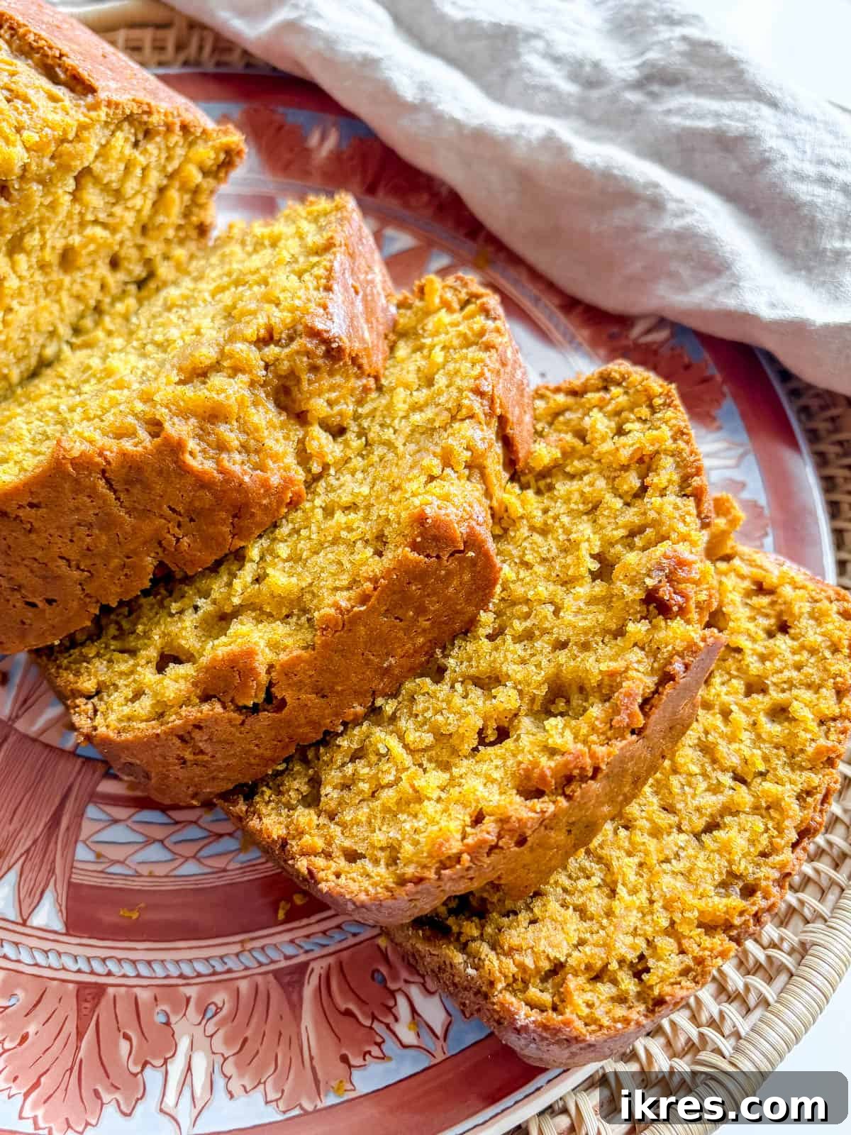 Autumn Spiced Dairy-Free Pumpkin Bread 10 Close-up of three thick slices of incredibly moist and flavorful dairy-free pumpkin bread on a white plate.