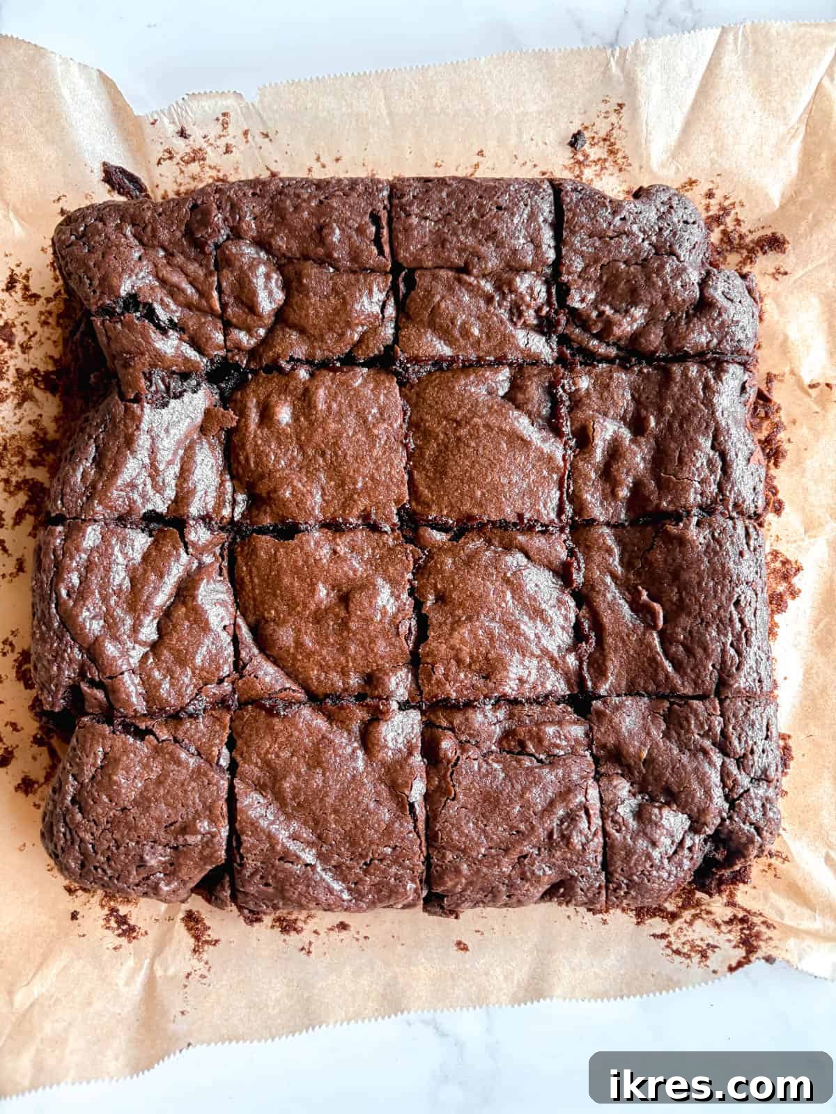 Liquid Gold Brownies 11 A hand cutting a square piece of warm olive oil brownie from the pan.